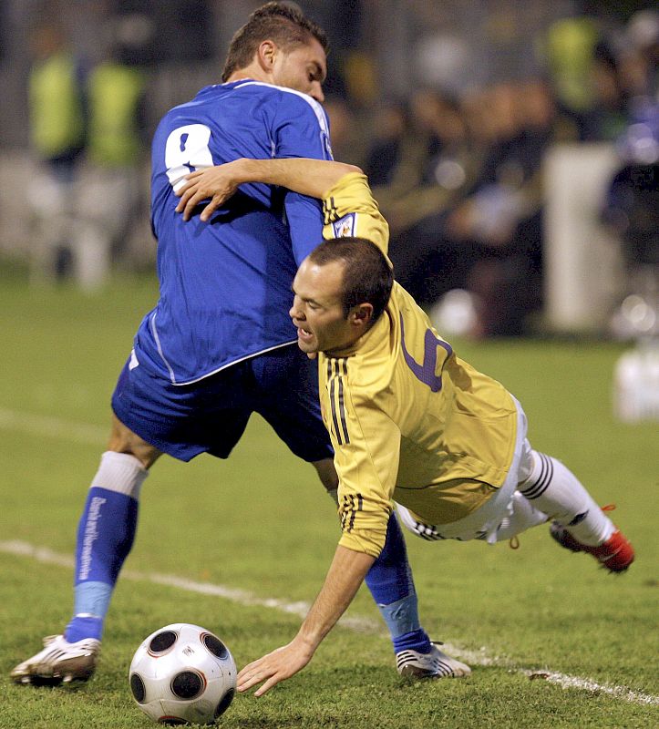 El centrocampista de la selección española Andrés Iniesta cae tras la entrada del centrocampista de Bosnia Herzegovina, Sanel Jahic.