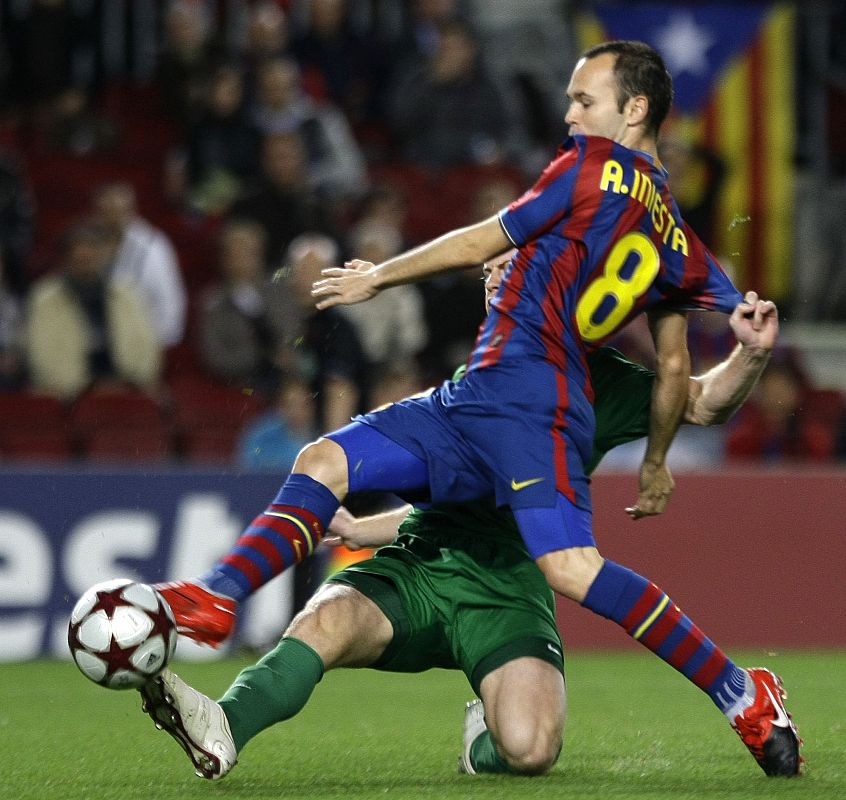 Barcelona's Andres Iniesta is challenged by Rubin Kazan's Ansaldi during their Champions League soccer match at the Camp Nou stadium in Barcelona
