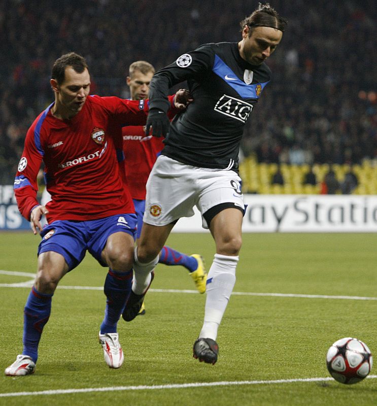 Berbatov se marcha con el balón controlado ante la presión de Ignashevich.