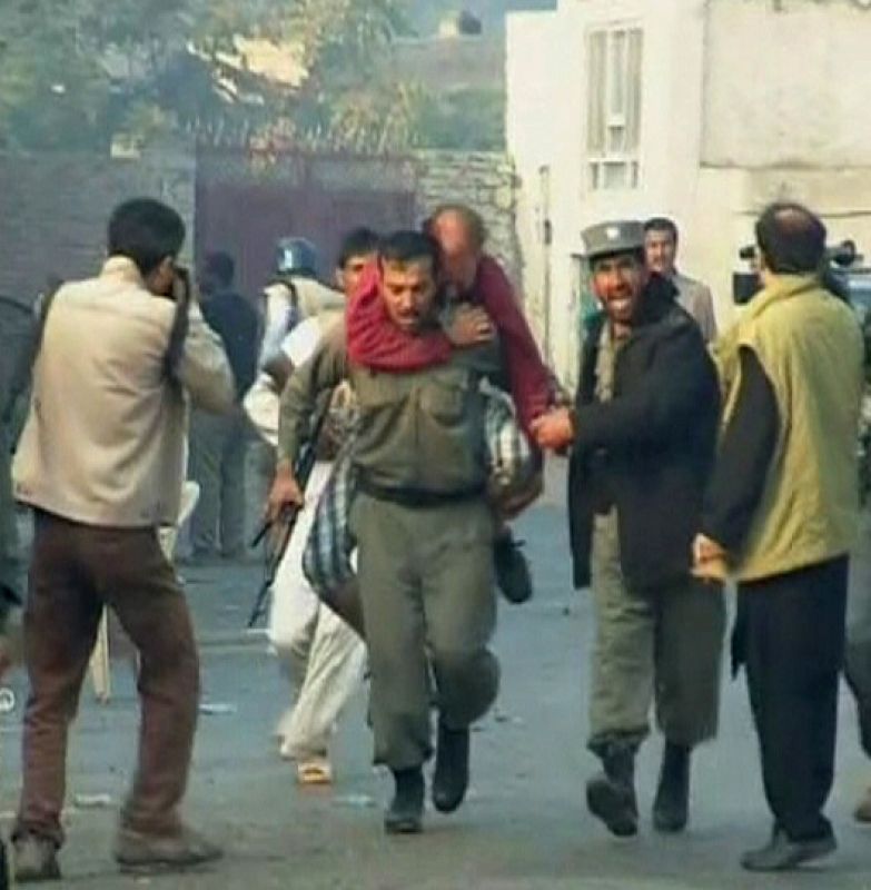 Un policía afgano rescata a un trabajador de la ONU herido en Kabul.