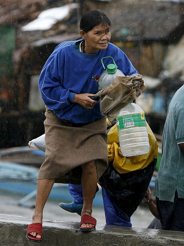 Una mujer lucha contra viento y lluvia durante el paso de un tifón en Bacoor, en la provincia de Cavite, Filipinas.