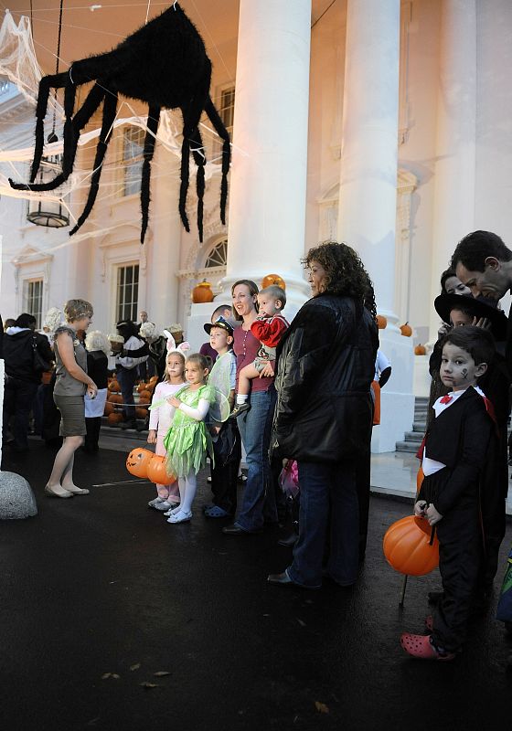 A spider hangs from the North Portico of the White House as local school children wait in line at a Halloween reception by US President Obama and his family in Washington