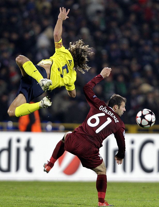 Barcelona's Puyol challenges Rubin Kazan's Karadeniz during their Champions League soccer match at the Central stadium in Kazan