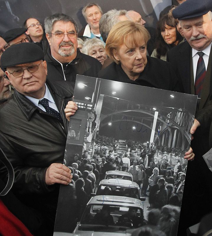 La canciller alemana, Angela Merkel, el ex-presidente de la Unión Soviética, Mijail Gorbachov, y el ex-presidente polaco, Lech Walesa, muestran una foto histórica del puente Bornholmenr.