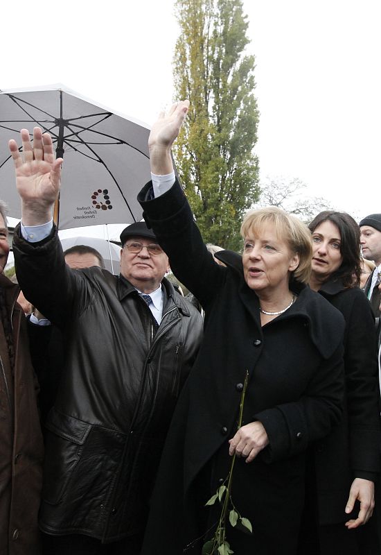 Ni la lluvia ha impedido que una exultante Angela Merkel cruzara el Bornholmer Strasse, la primera grieta que se abrió en el Muro de Berín hace 20 años.
