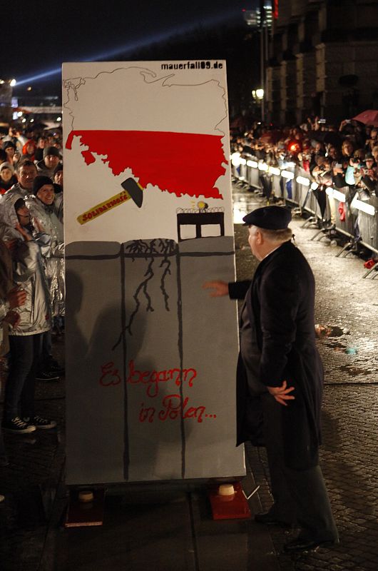 Former Polish President Walesa pushing the first domino block on the corner of the Reichstag Gate in Berlin during celebrations to mark the 20th anniversary of the fall of the Berlin Wall