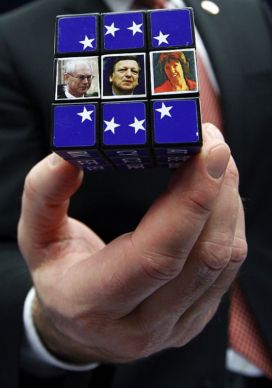 Sweden's PM Reinfeldt holds a Rubick's cube showing pictures of EU President Van Rompuy, EC President Barroso and EU foreign policy chief Ashton in Brussels