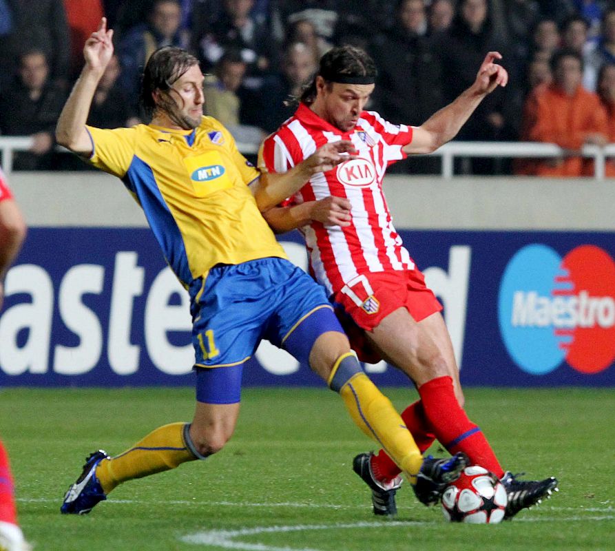 Kamil Kosowski del FC Apoel lucha por el balón con el defensa checo Atlético de Madrid Tomas Ujfalusi.