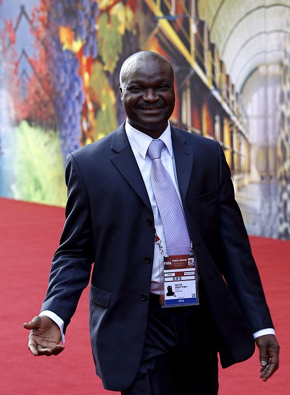 La leyenda del fútbol camerunés Roger Milla sonríe a su llegada a la ceremonia del sorteo de grupos.