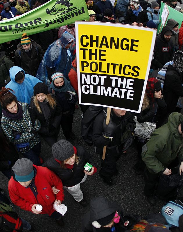 Protestors hold signs as they march towards the Bella Center during a demonstration in Copenhagen