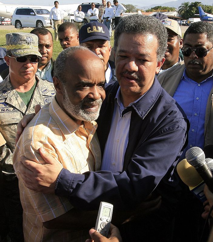 Haiti's President Rene Preval (2nd L) embraces his Dominican Republic counterpart Leonel Fernandez at the national airport as they finish a meeting with U.N representatives in Port-au-Prince