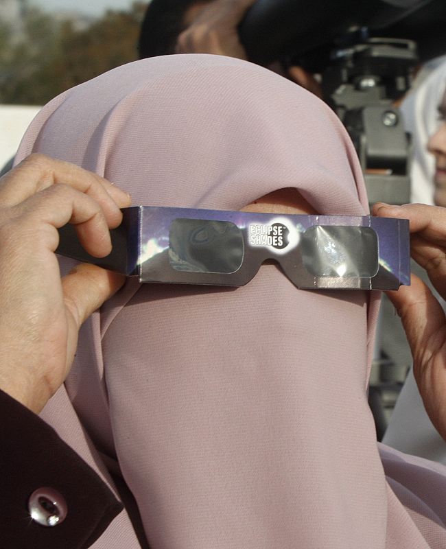 Una mujer observa el eclipse con unas gafas especiales en Amman