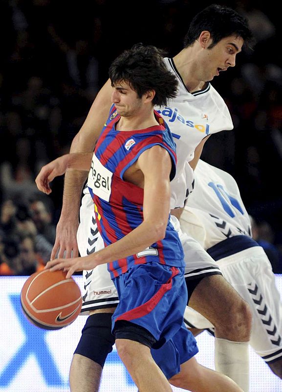 El base del Regal FC Barcelona, Ricky Rubio, controla el balón ante la defensa de Triguero.