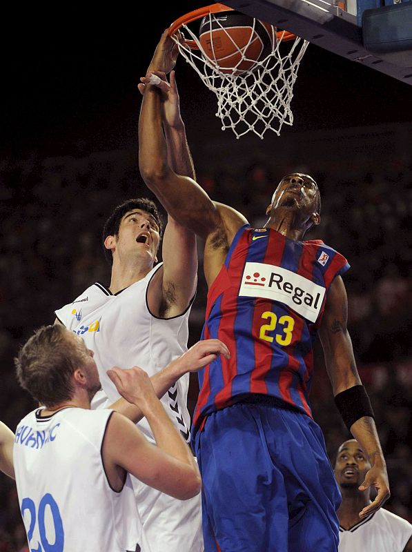 El jugador estadounidense del F. C. Barcelona, Terence Morris, "machaca" la canasta ante el jugador del Cajasol, Triguero.