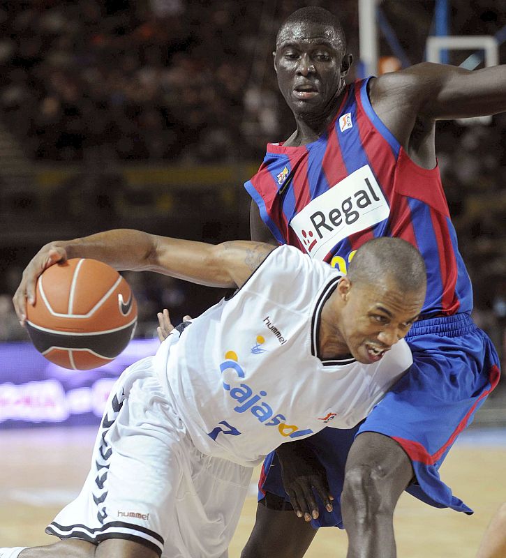 El escolta estadounidense del Cajasol, Tyrone Gerard Ellis, intenta superar la defensa del pivot senegalés del F. C. Barcelona, Boniface Ndong.