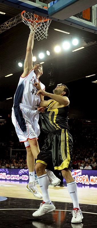 El pívot croata del Caja Laboral Baskonia, Stanko Barac, machaca la canasta ante el pívot del Real Madrid, Felipe Reyes.