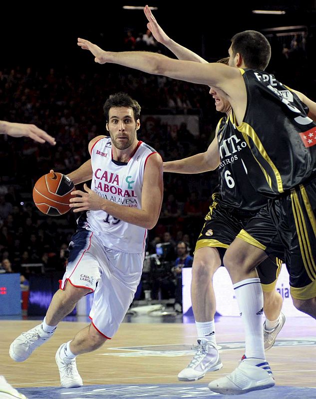 El pívot del Real Madrid, Felipe Reyes, intenta evitar el avance del escolta del Caja Laboral Baskonia, San Emeterio.