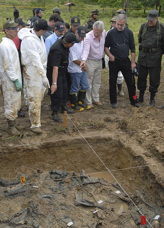 Commander of Colombia's National Police Naranjo and prosecutors look at a mass grave in Turbo province