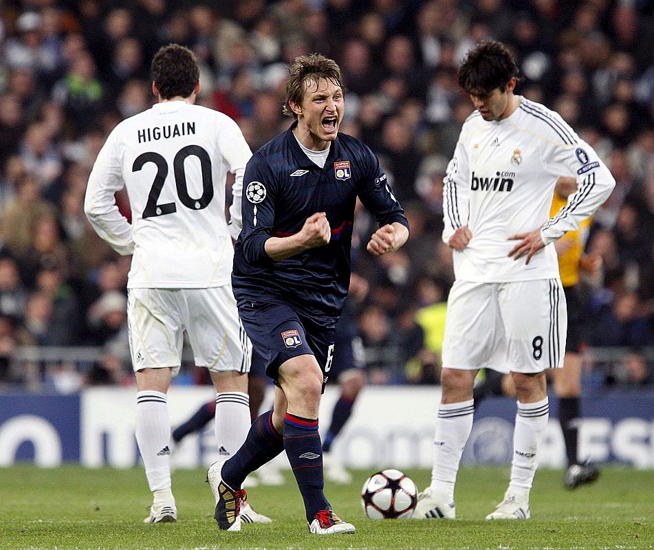 El jugador bosnio del Olympique de Lyon, Pjanic, celebra ante los jugador del Real Madrid, Kaká y Gonzalo Higuain, el gol del equipo francés.