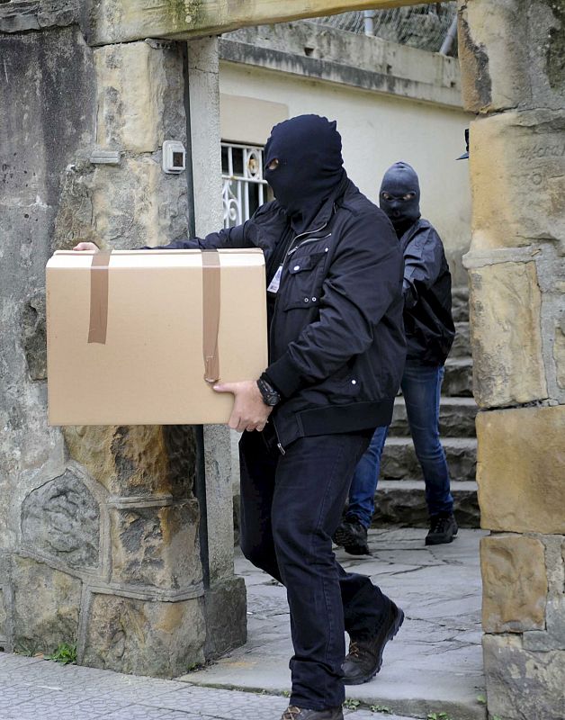 Agentes de la Ertzaintza transportan cajas con documentación.