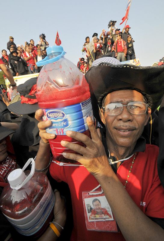 Un manifestante muestra una botella llena de sangre, donada por otros opositores