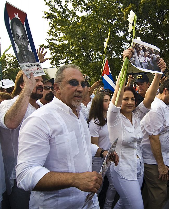 La cantante Gloria Estefan y su esposo Emilio sostienen fotografías de las Damas de Blanco