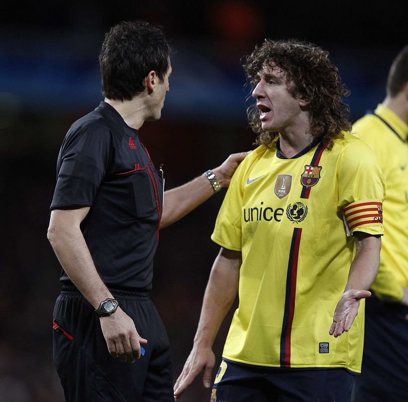 Puyol pide explicaciones a Massimo Busacca tras el penalti sobre Cesc.