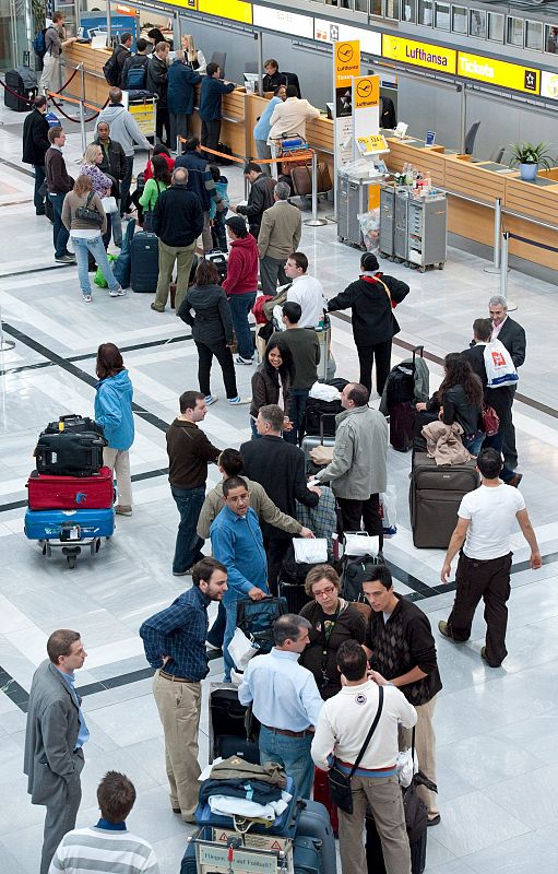 Un grupo de pasajeros hace cola ante un mostrador del aeropuerto germano de Stuttgart.