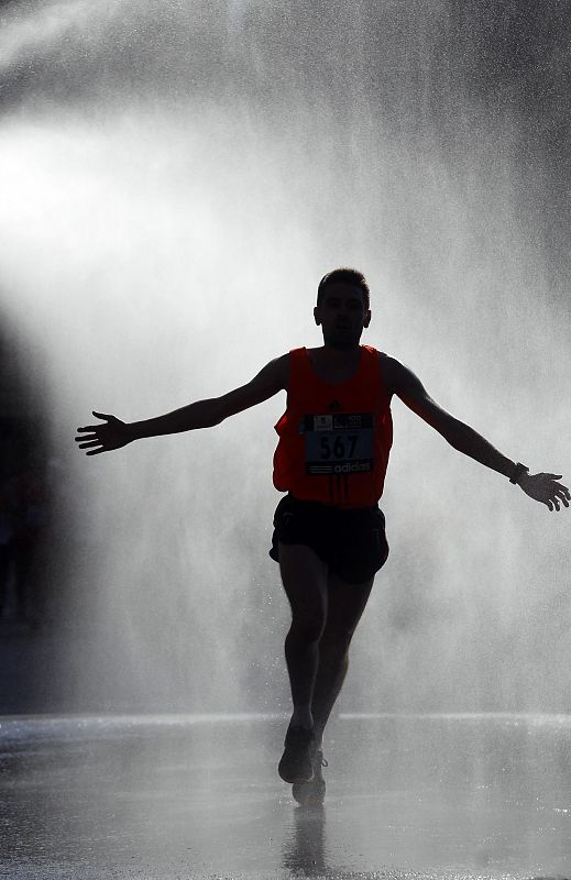 A runner goes through water sprinklers during the XXXIII Madrid marathon