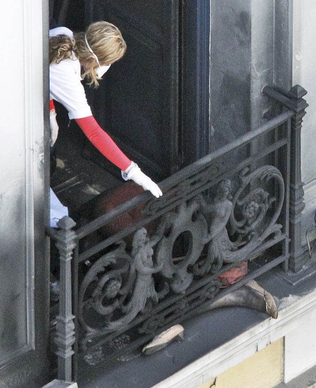 Un médico se dispone a retirar el cuerpo de una de las personas que ha fallecido este miércoles en un banco griego que fue prendido fuego durante las protestas en Atenas.