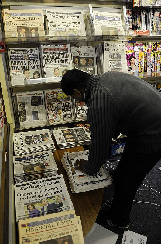 Un vendedor de prensa organiza los periódicos.