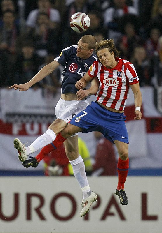 Hangeland y Forlán pugnan en el aire por un balón.