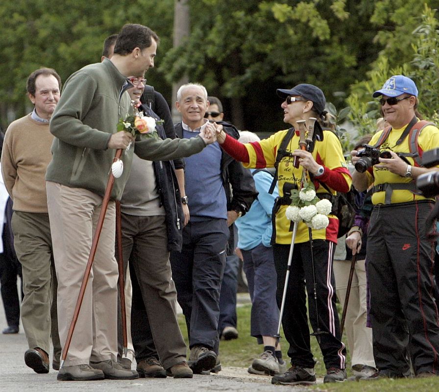 El Príncipe Felipe saluda a una una mujer, que al igual que él, estaba recorriendo esta mañana el Camino de Santiago.