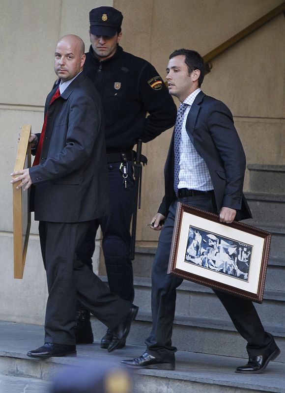 Spanish judge Baltasar Garzon's assistants carry two pictures belonging to him outside the Spain's High Court in Madrid