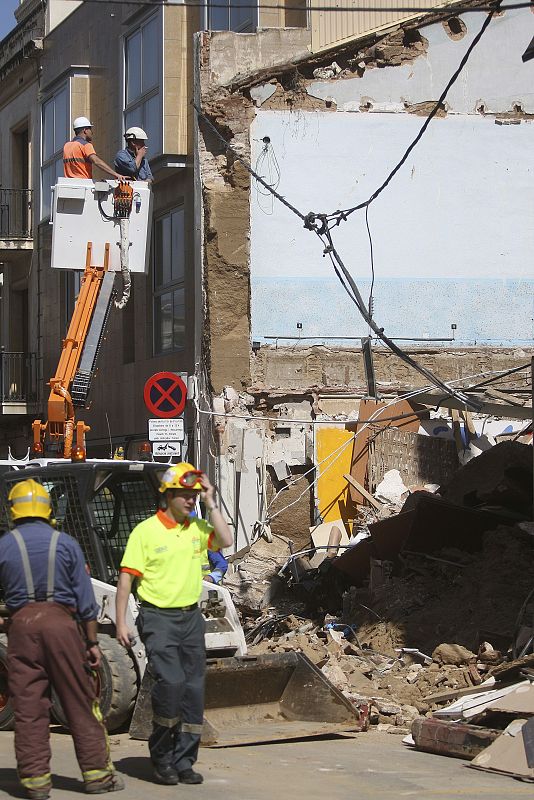 Un grupo de bomberos registra los escombros en busca de víctimas.