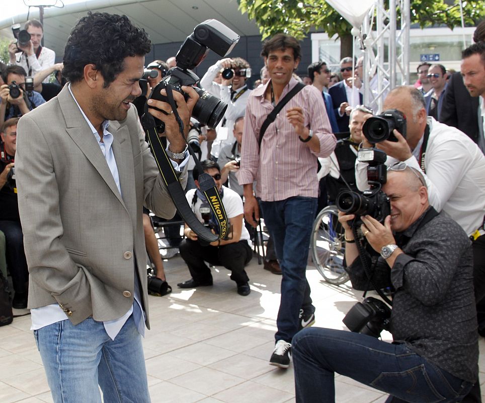 Cast member Debbouze jokes using camera of a photographer during a photocall at the 63rd Cannes Film Festival