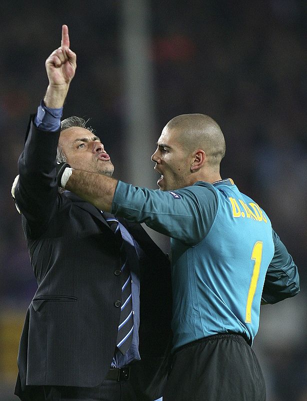 El portero del Barcelona, Víctor Valdés, detiene la carrera de Mourinho por el césped del Camp Nou tras la victoria del Inter en la Ciudad Condal.