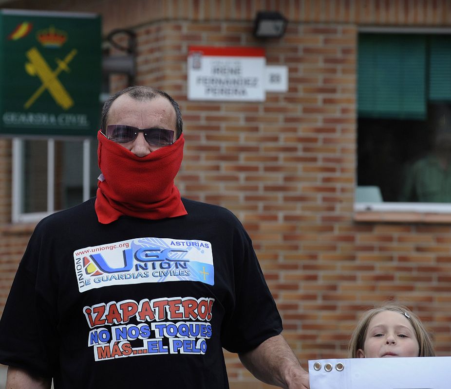 A masked Spanish civil guard protests against the government during a general strike called by the public sector in Gijon