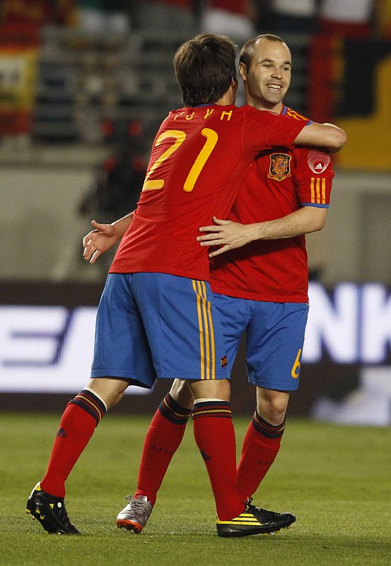 Spain's Silva celebrates with his teammate Iniesta his goal during a friendly soccer match against Poland in Murcia