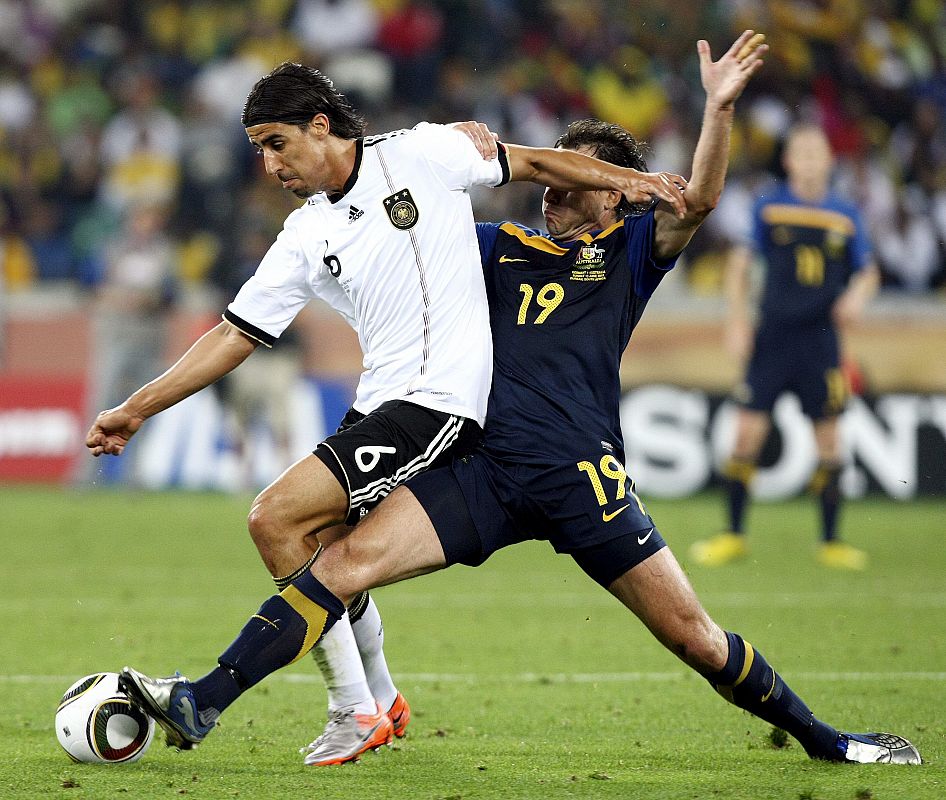 Richard Garcia de Australia lucha por el blón con Sami Khedira de Alemania.