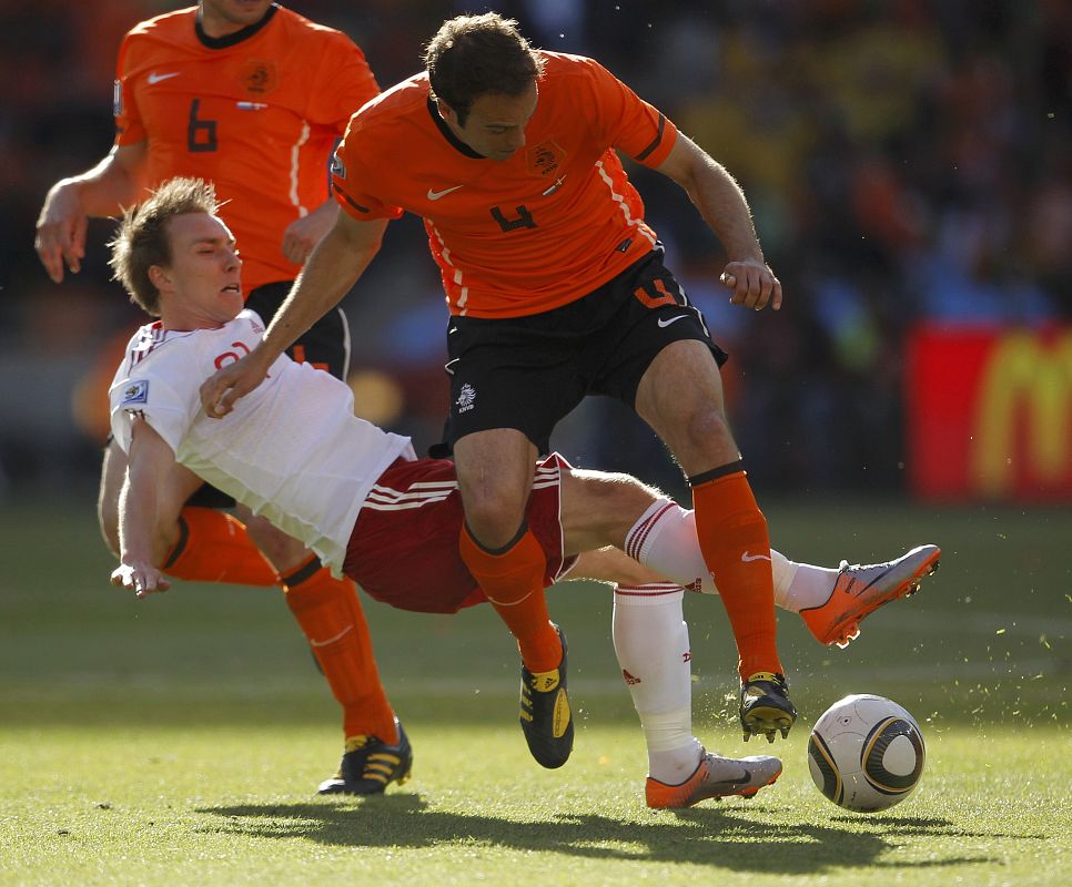 El jugador danés Christian Eriksen (I) pelea por la pelota con el holandés Joris Mathijsen.