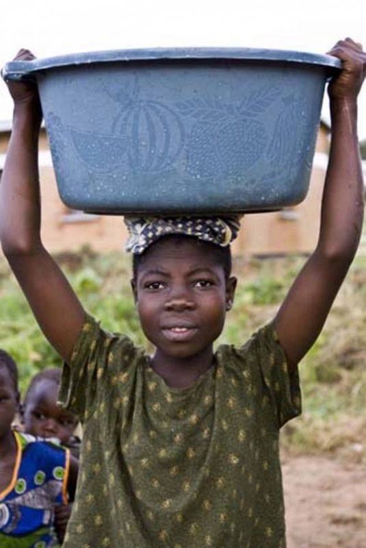 Mujer sosteniendo cubo de agua depurada en Atupele, Malawi.