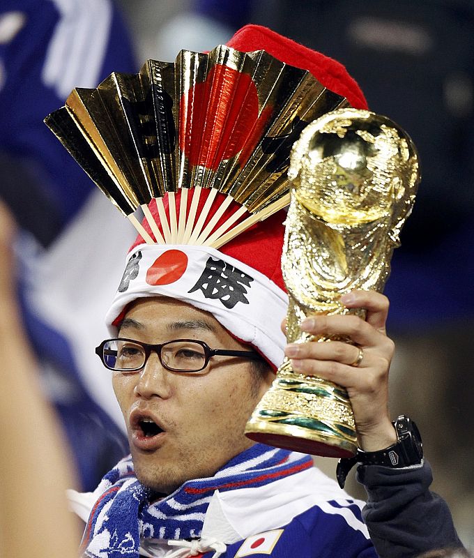 A fan holds a mock World Cup trophy during the 2010 World Cup Group E soccer match between Japan and Cameroon at Free State stadium in Bloemfontein