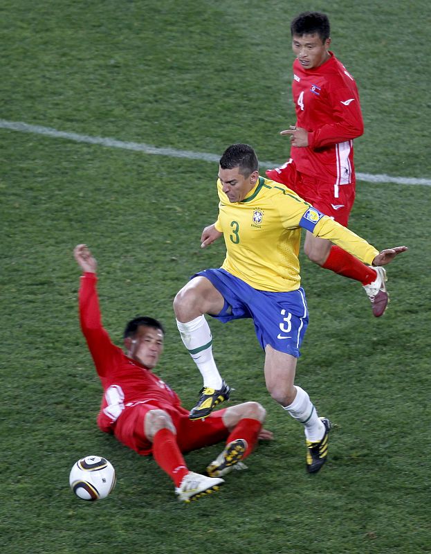 El brasileño Lucio pugna por el balon con el coreano Pak Nam-chol.