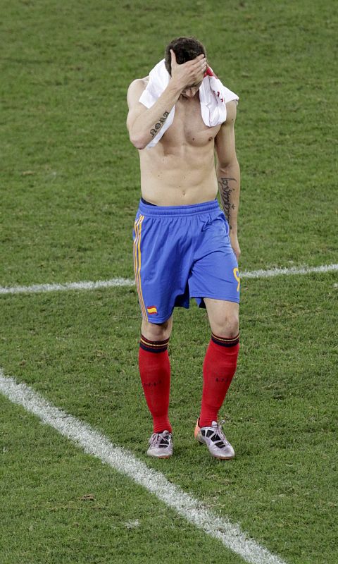 Fernando Torres, con la camiseta de un jugador suizo sobre los hombros, abandona el campo muy triste tras la derrota de España.