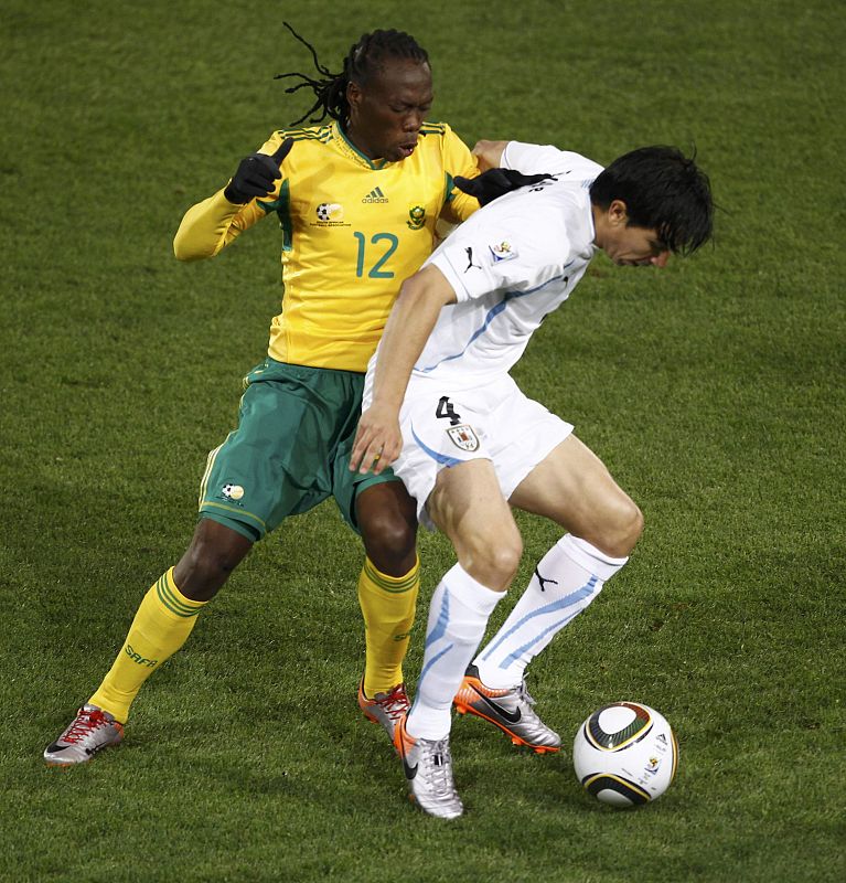 South Africa's Letsholonyane fights for the ball against Uruguay's Fucile during the 2010 World Cup Group A soccer match at Loftus Versfeld stadium in Pretoria