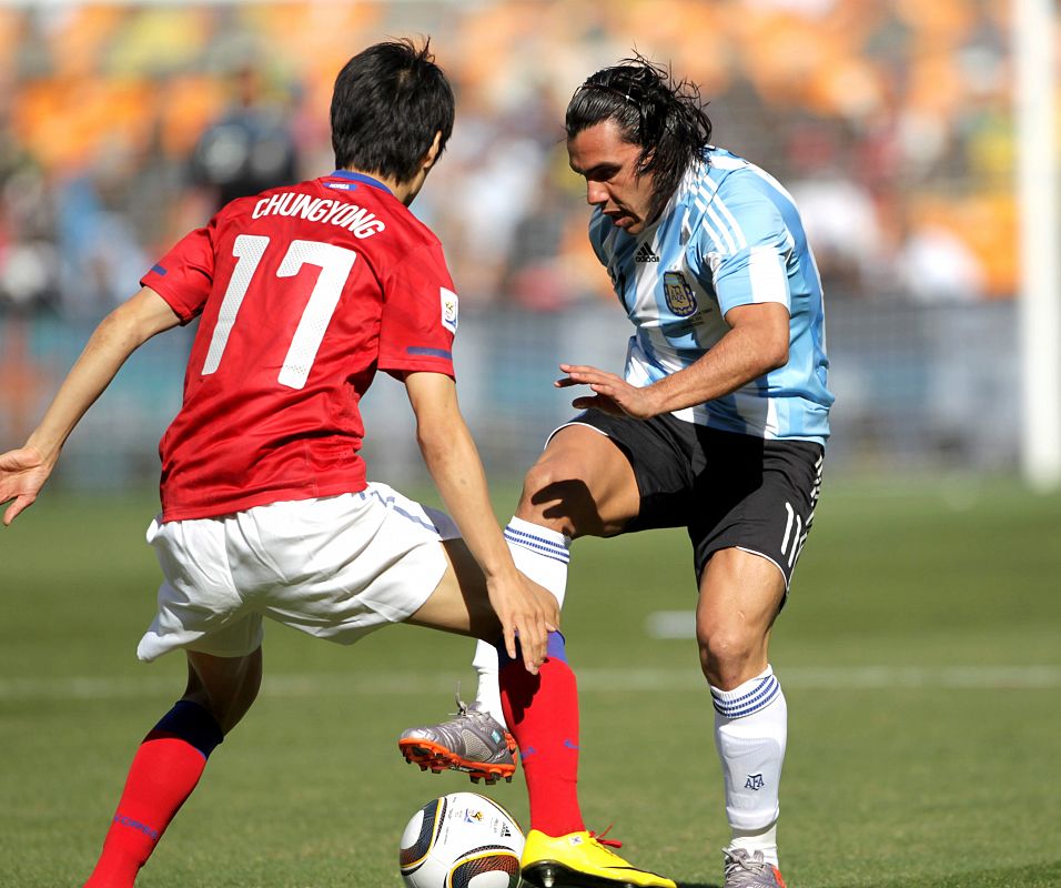 El centrocampista argentino Carlos Tevez controla la pelota ante la oposición del  surcoreano Lee Chung Yong.