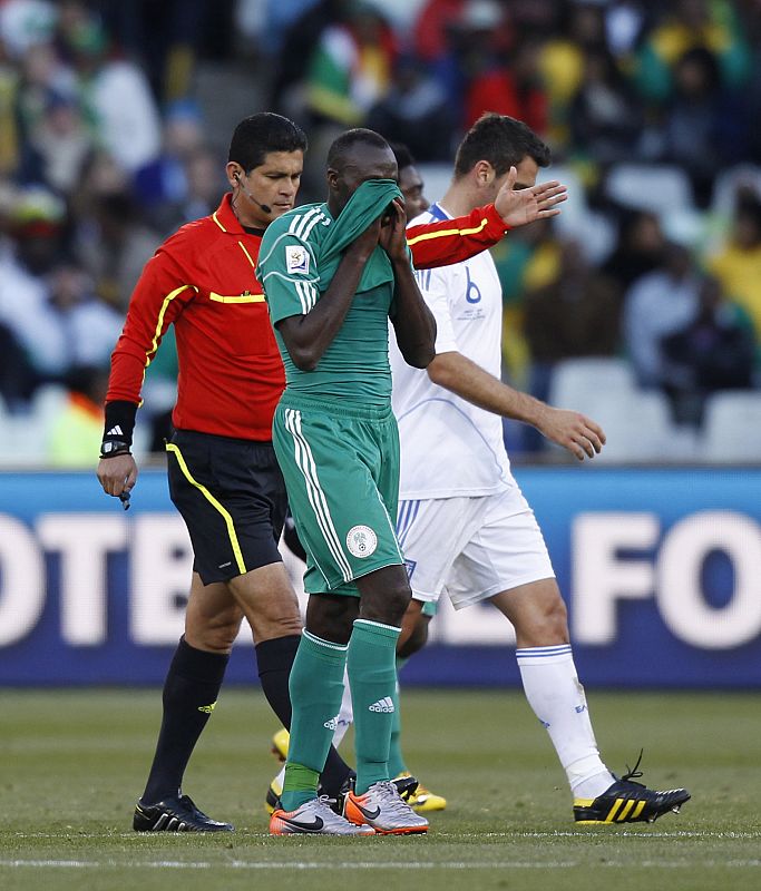 El nigeriano Kaita se retira del terreno de juego después de haber visto una tarjeta roja por agredir al griego Torosidis cuando la pelota no estaba en juego.in Bloemfontein