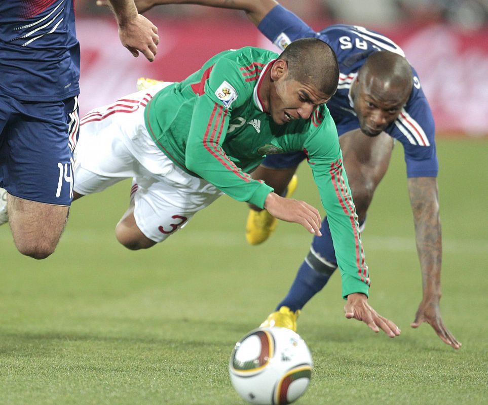 El mexicano Carlos Salcido, cae ante Eilliam Gallas durante el partido que ha enfrentado a las selecciones de Francia y México.