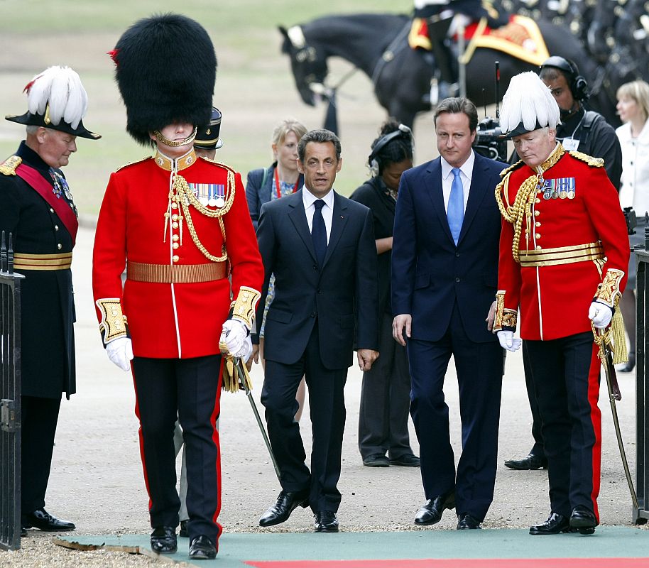David Cameron y Nicolás Sarkozy, escoltados por la guardia real británica.